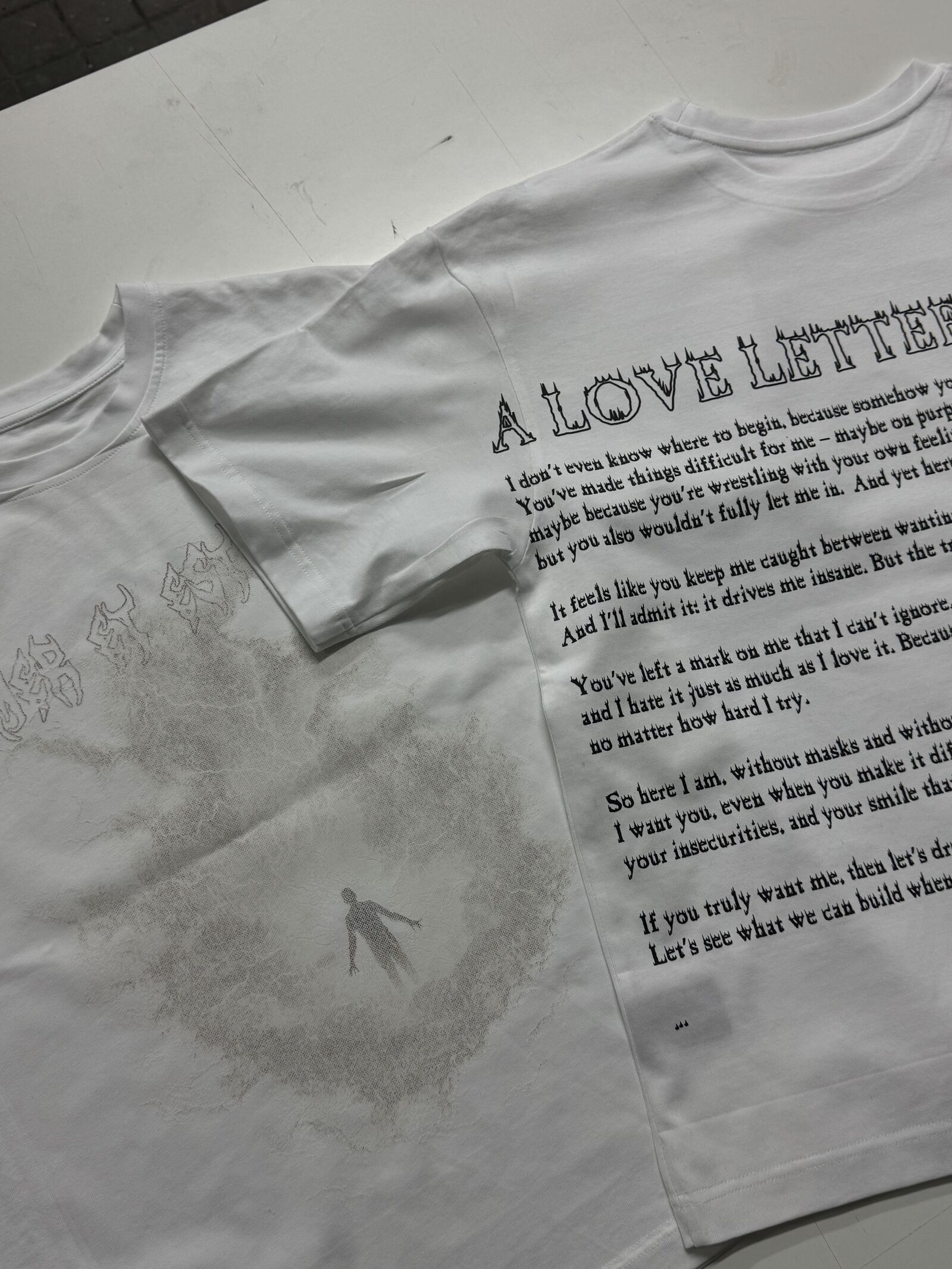 Two white t-shirts with front tonal print and back typographic layout