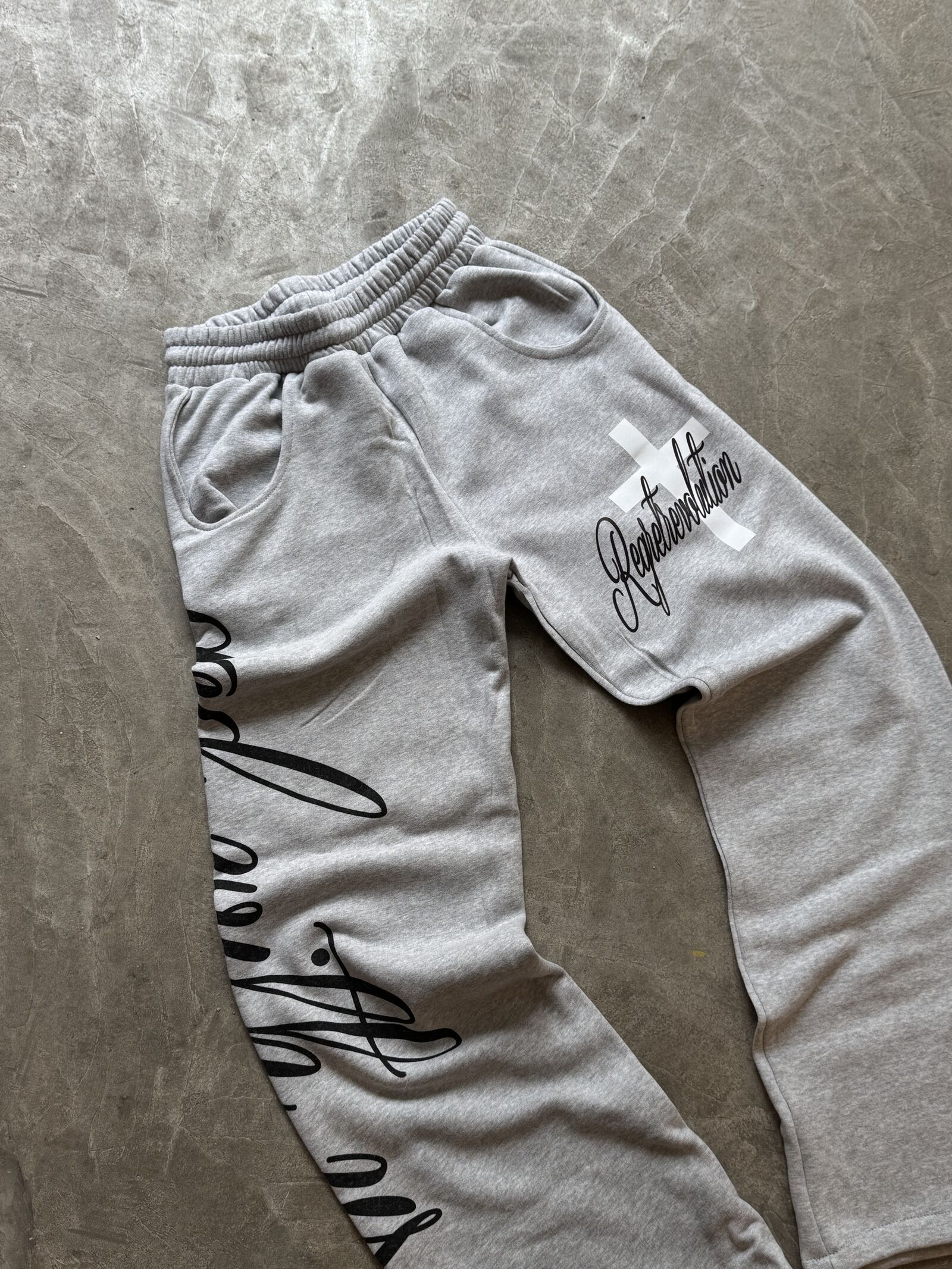 Grey heather joggers with printed typography and cross graphic